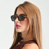 Woman wearing sunglasses with a neutral background