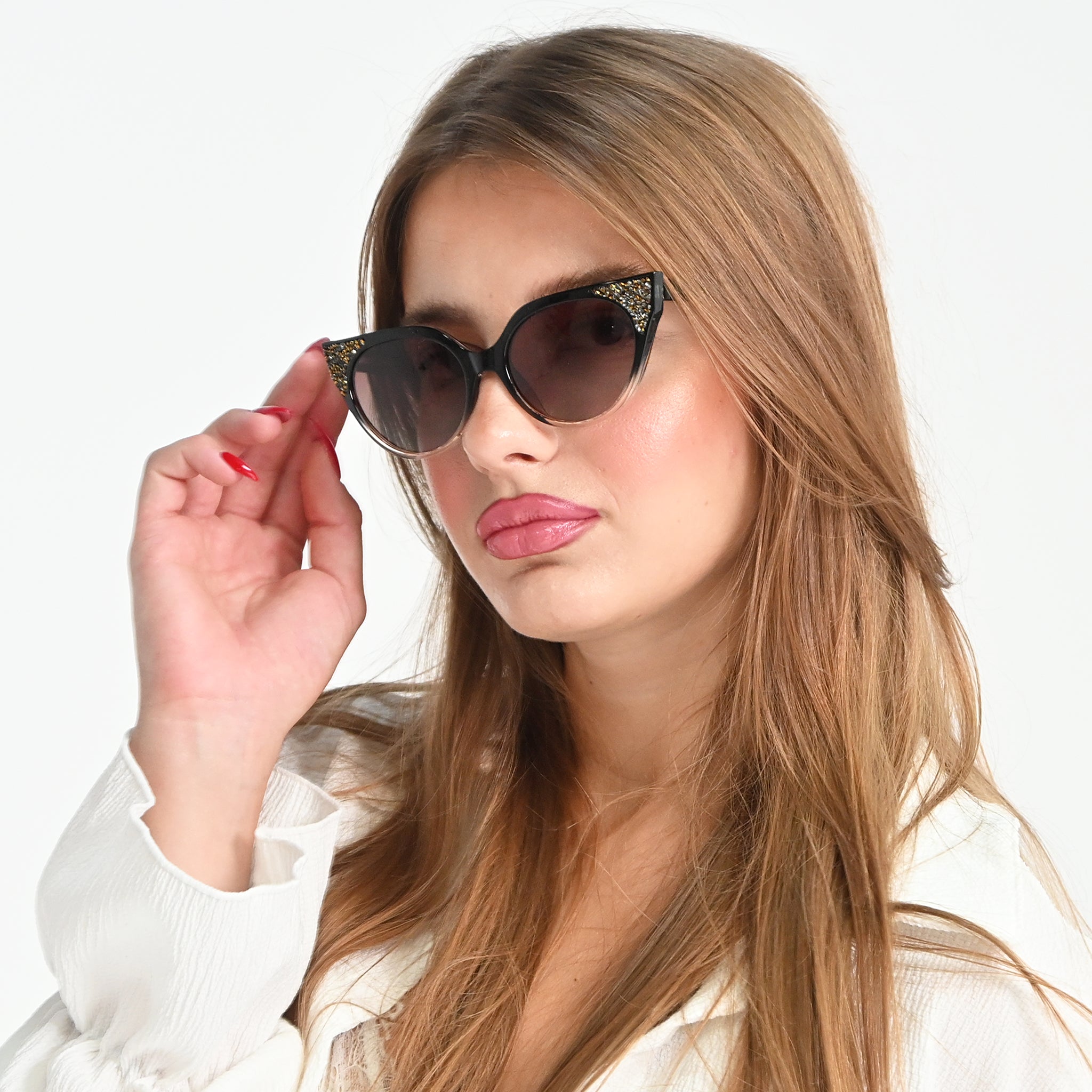 Woman wearing cat-eye sunglasses with a plain background