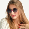 Woman wearing stylish sunglasses with a neutral background