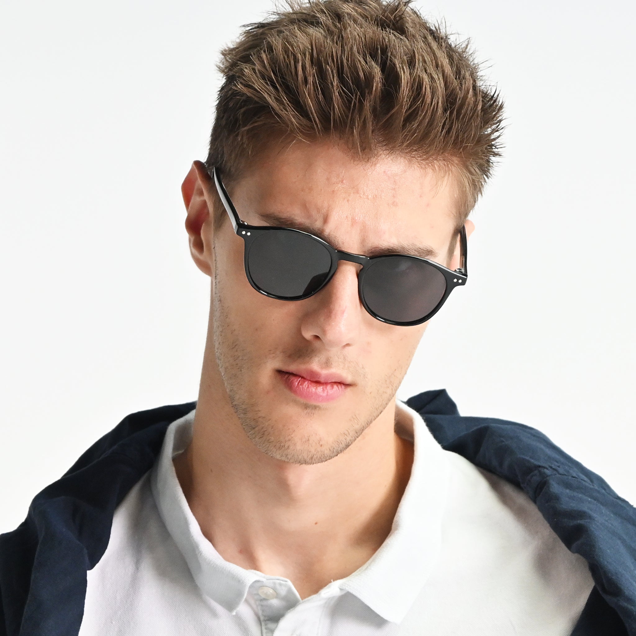 Man wearing dark sunglasses with a white background