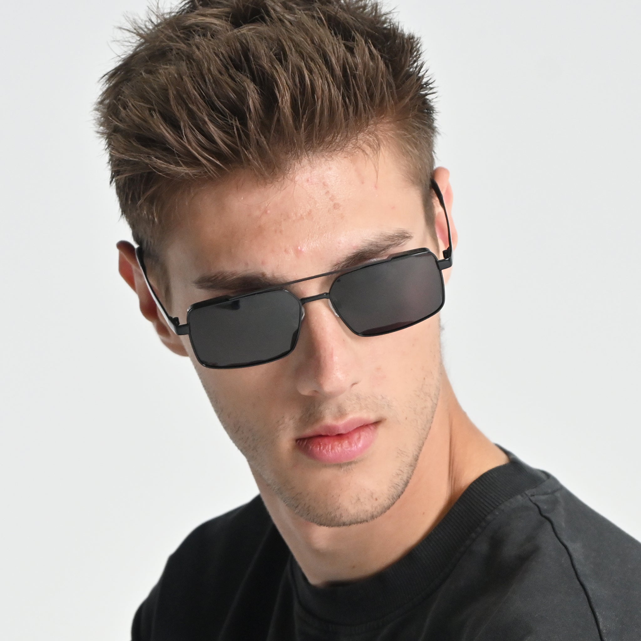 Man wearing black sunglasses with a plain background