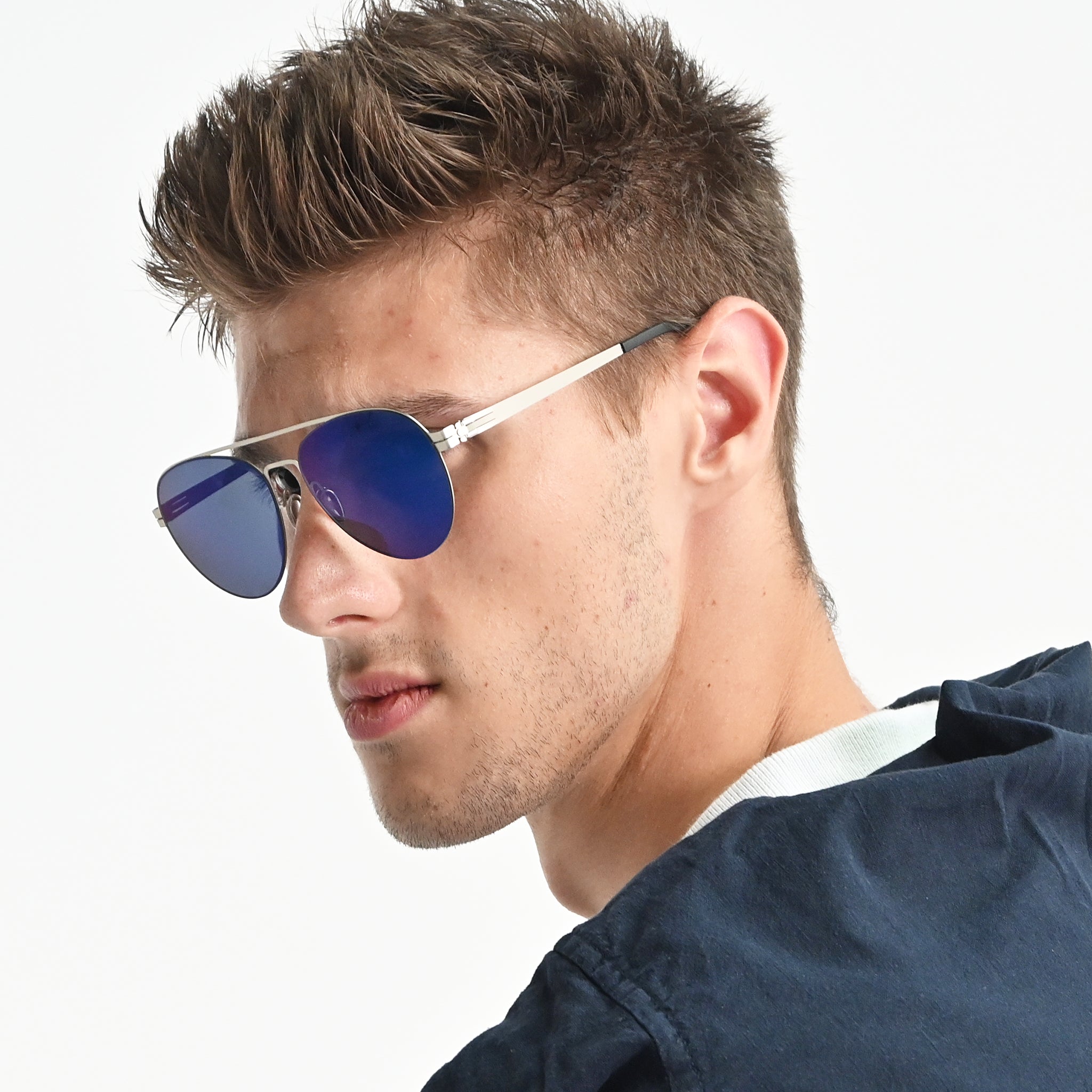 Man wearing blue reflective sunglasses with a white background