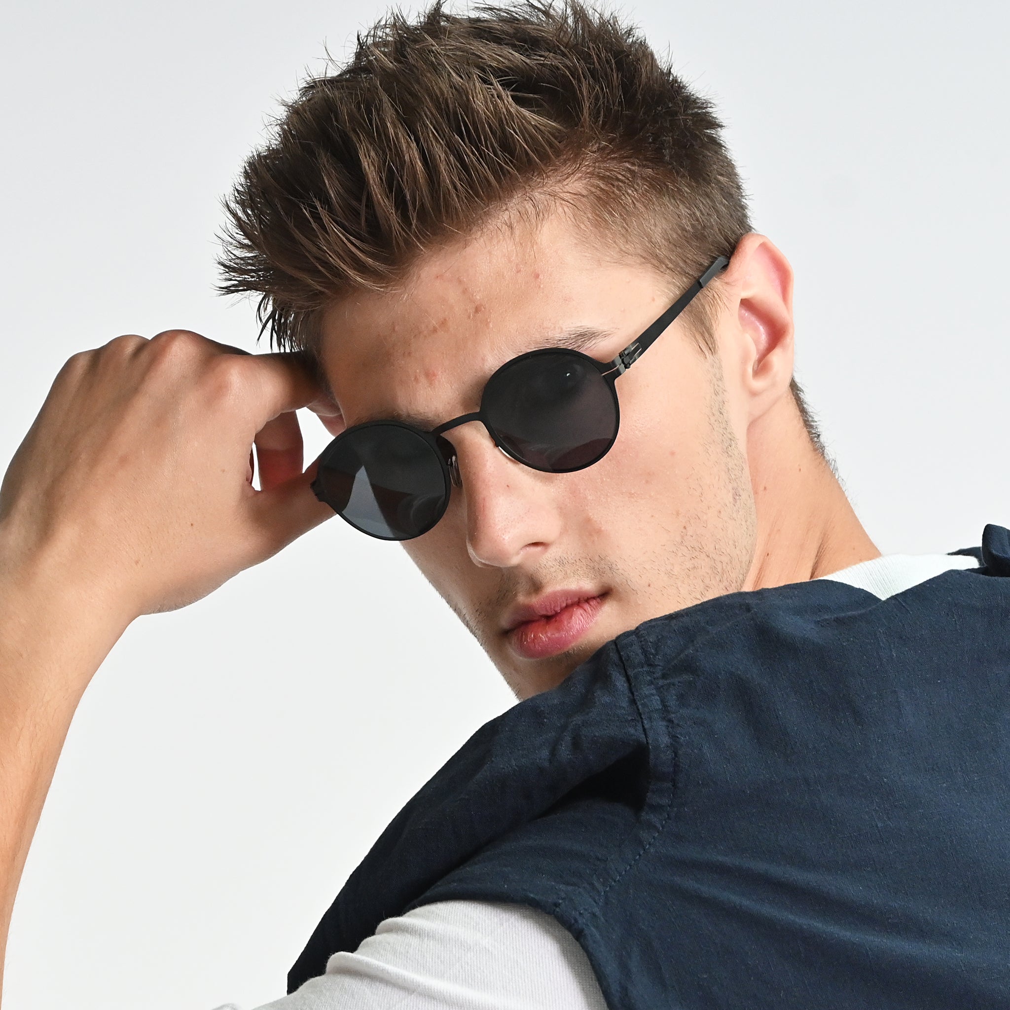 Man wearing black sunglasses with a neutral background