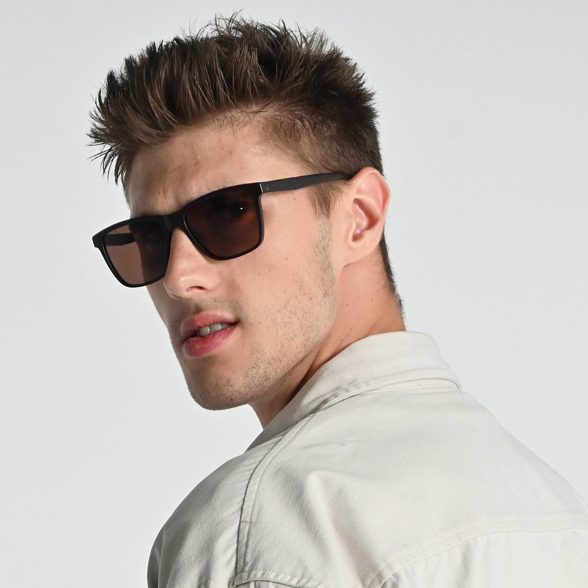 Man wearing sunglasses with a neutral background