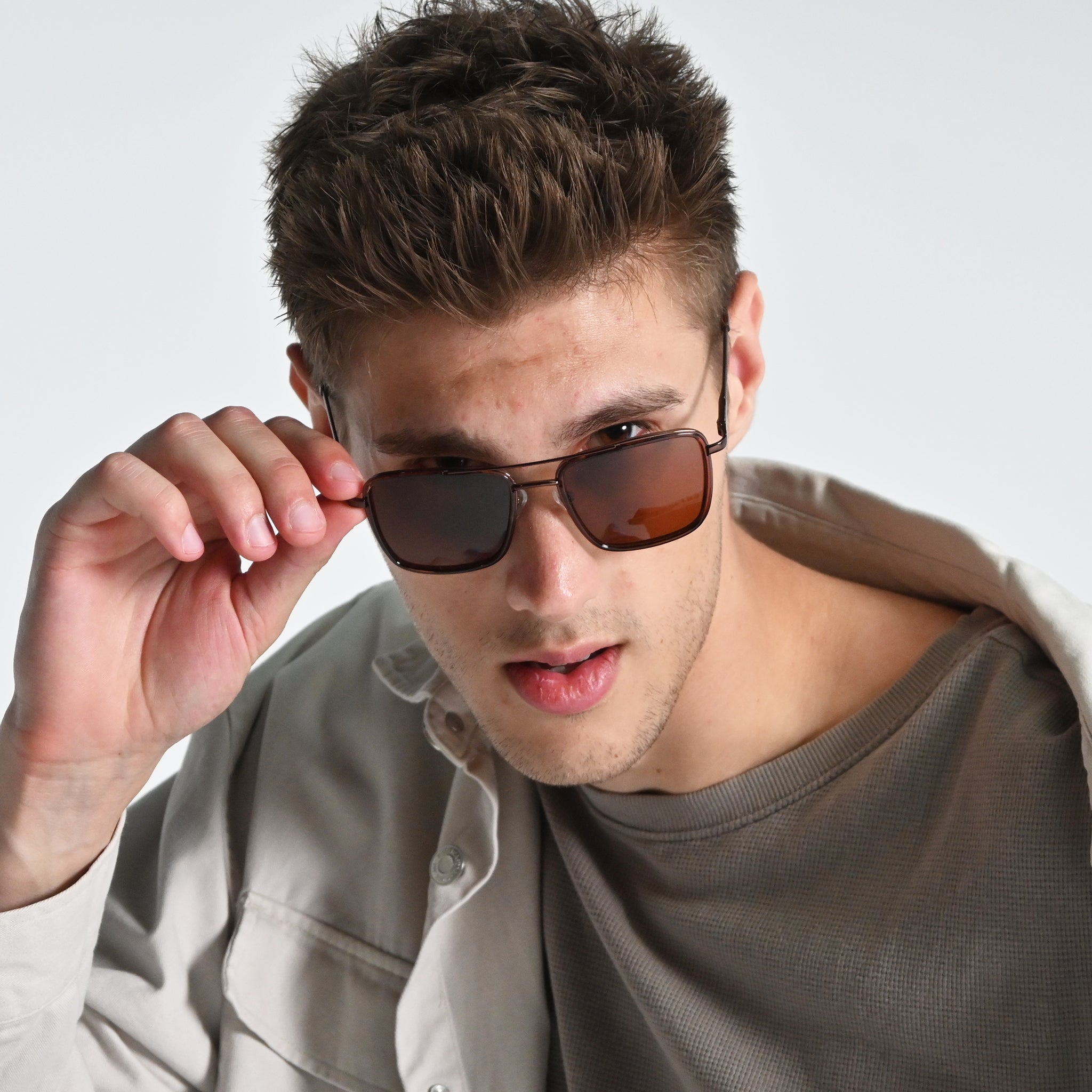 Man wearing sunglasses with a neutral background
