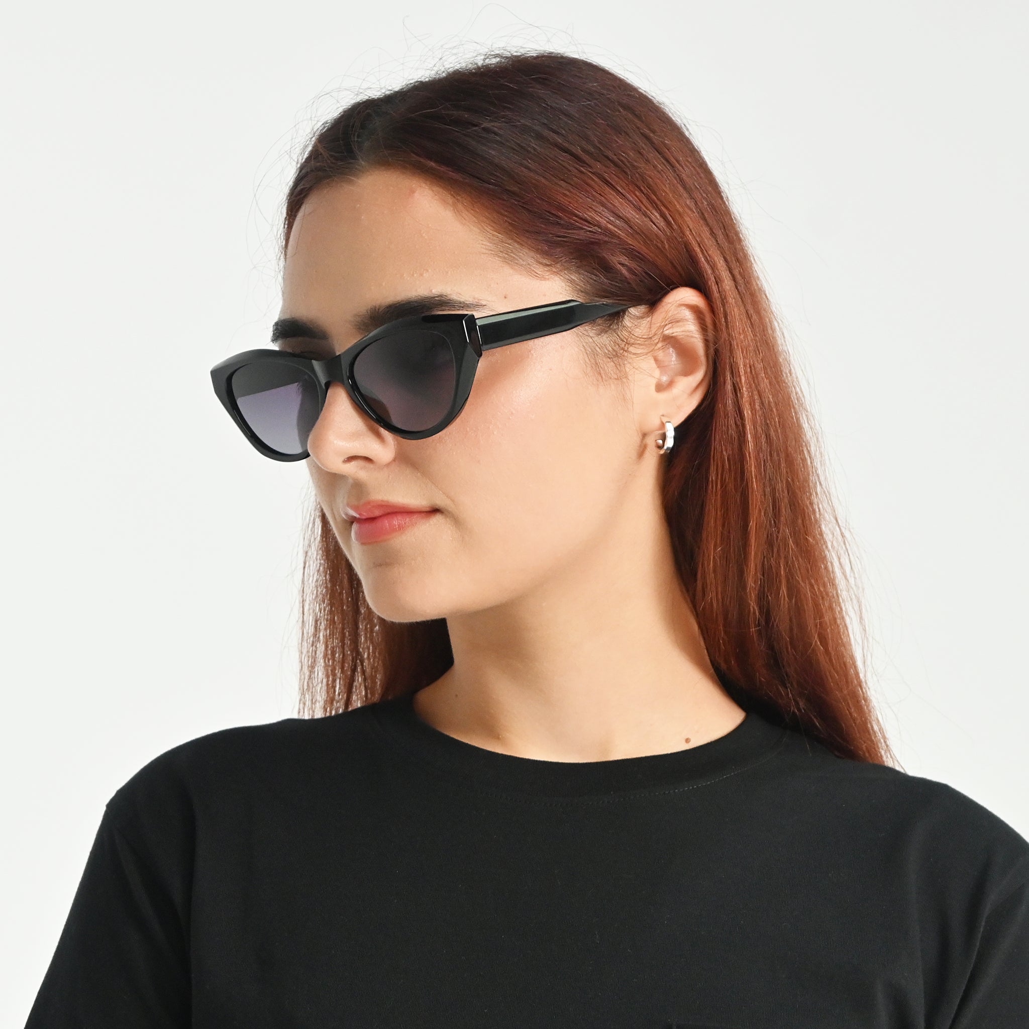 Woman wearing black sunglasses with a plain background
