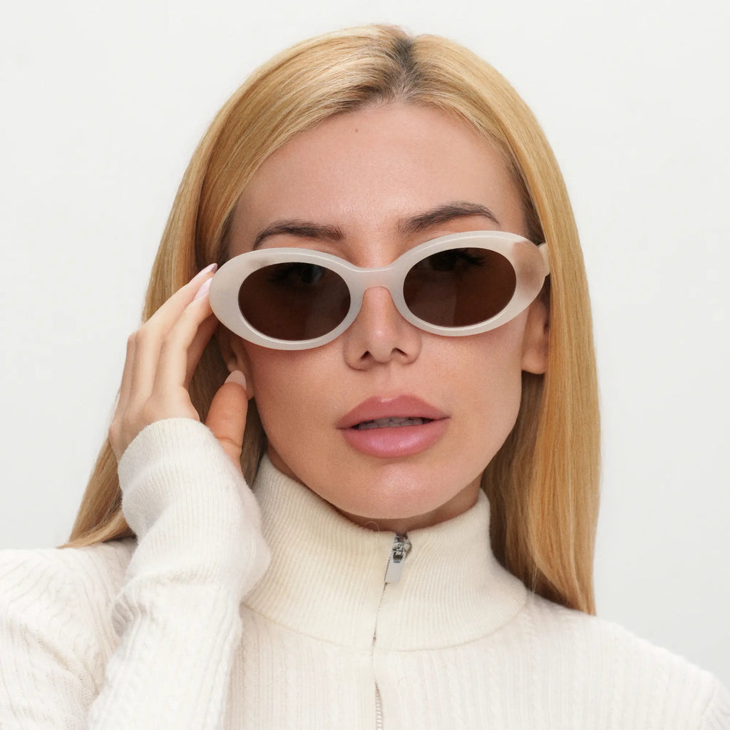 Woman wearing a pair of sunglasses with a plain background