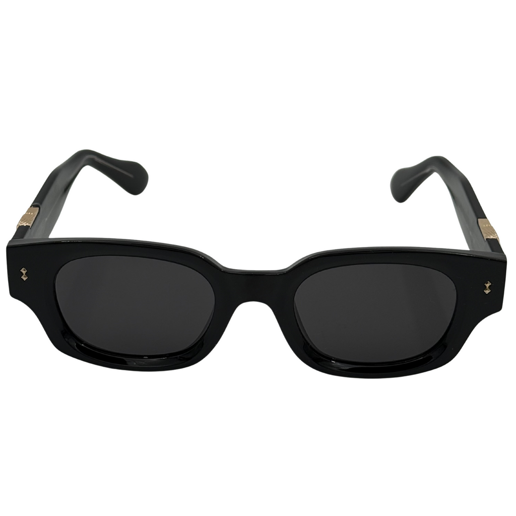 Black sunglasses with gold accents on a white background