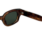 Sunglasses with tortoiseshell frame and dark lenses on a white background