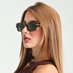Woman wearing sunglasses with a neutral background