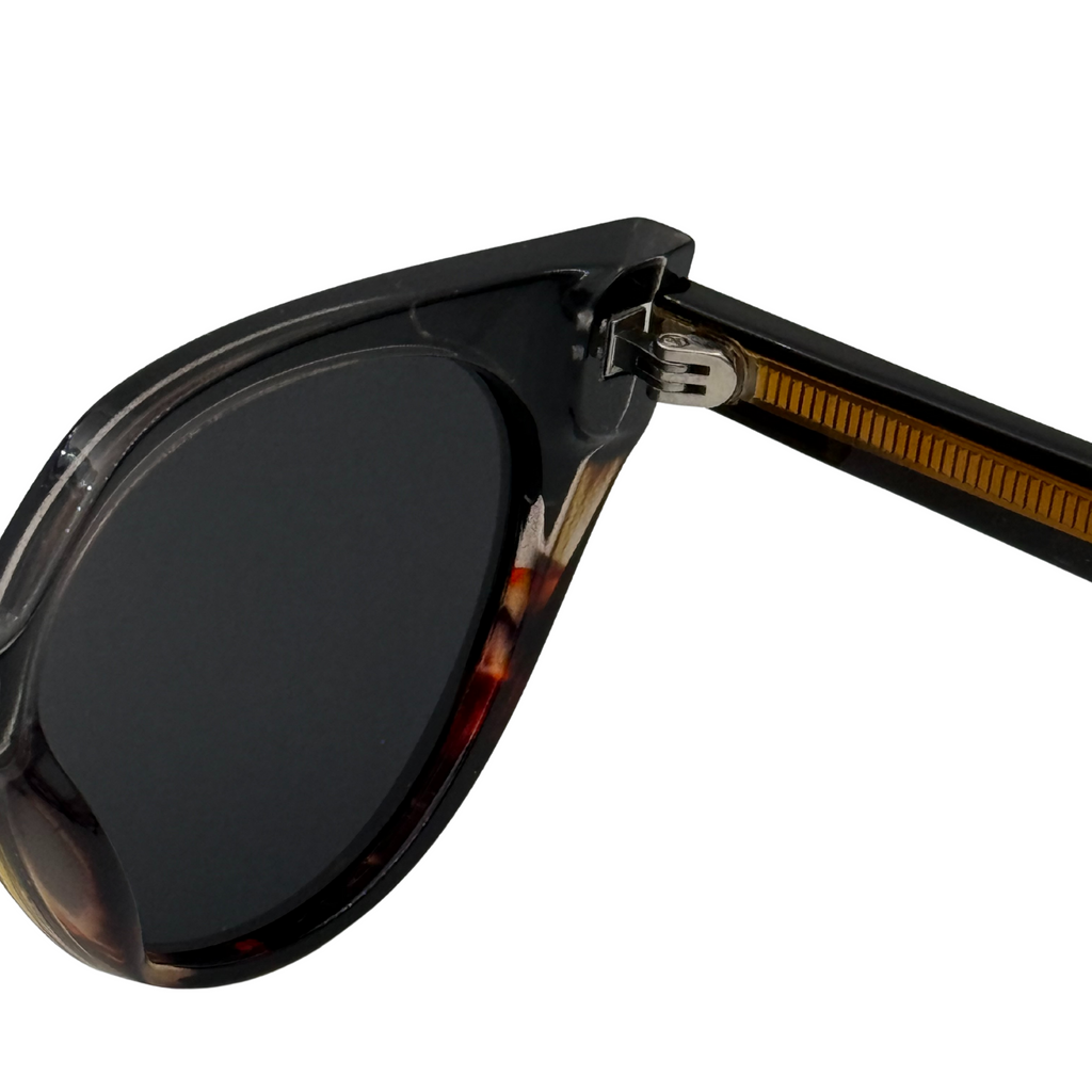 Close-up of a sunglasses with tortoiseshell frame and dark lenses on a white background