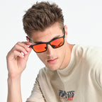 Man wearing sunglasses with orange lenses on a white background