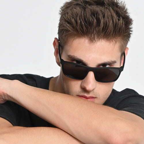 Man wearing sunglasses with a neutral background