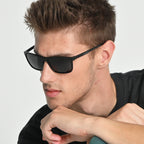 Man wearing black sunglasses with a neutral background