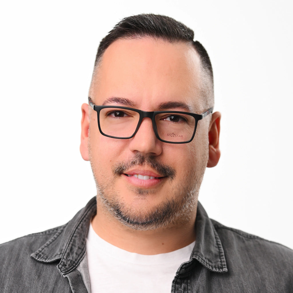 Man wearing black glasses and a gray jacket on a white background