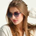 Woman wearing sunglasses with a neutral background