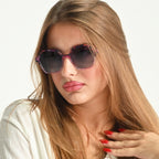 Woman wearing stylish sunglasses with a neutral background
