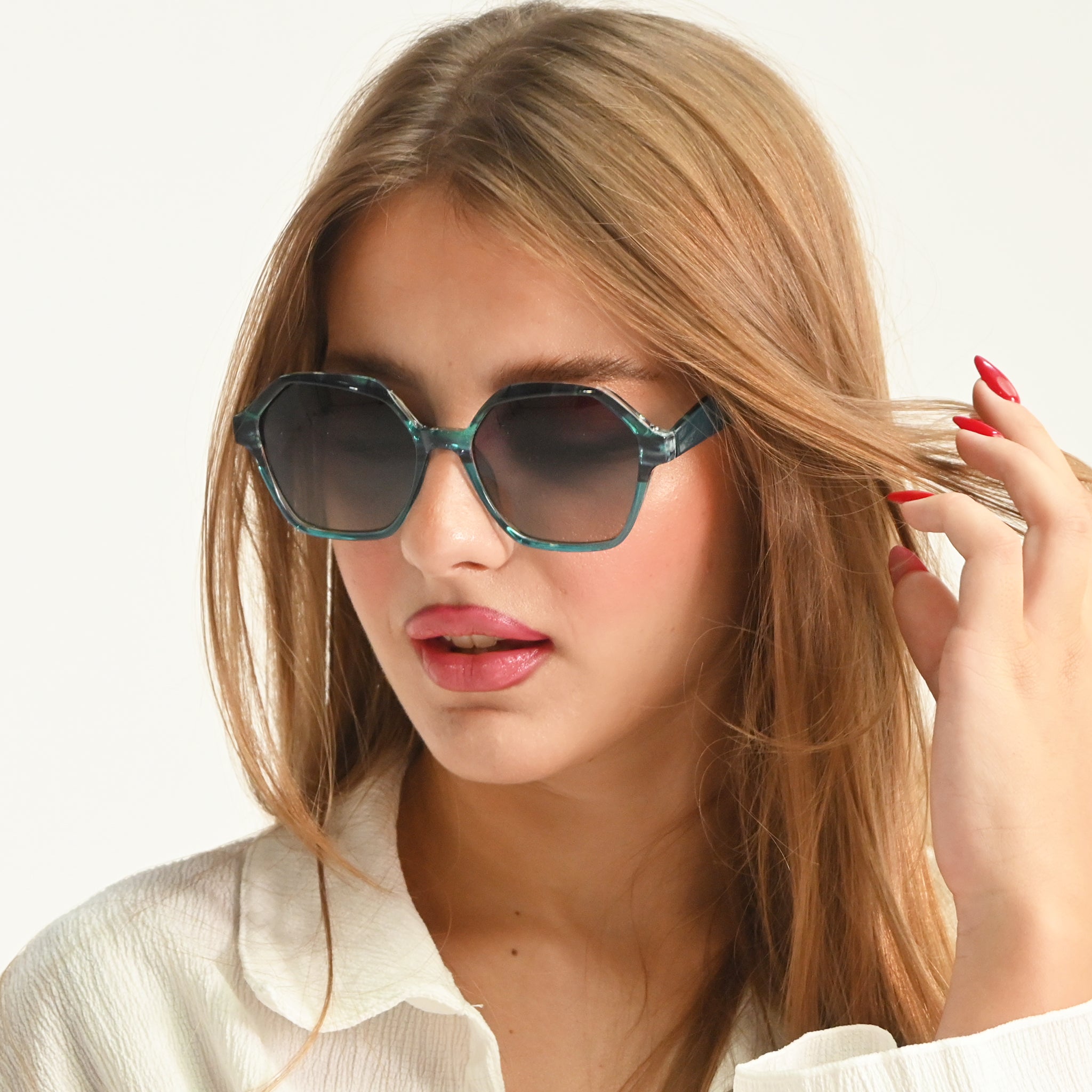 Woman wearing stylish sunglasses with a plain background