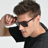 Man wearing black sunglasses with a neutral background
