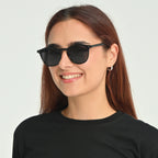 Woman wearing black sunglasses with a plain background