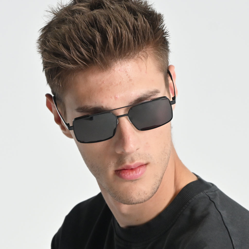 Man wearing black sunglasses with a plain background