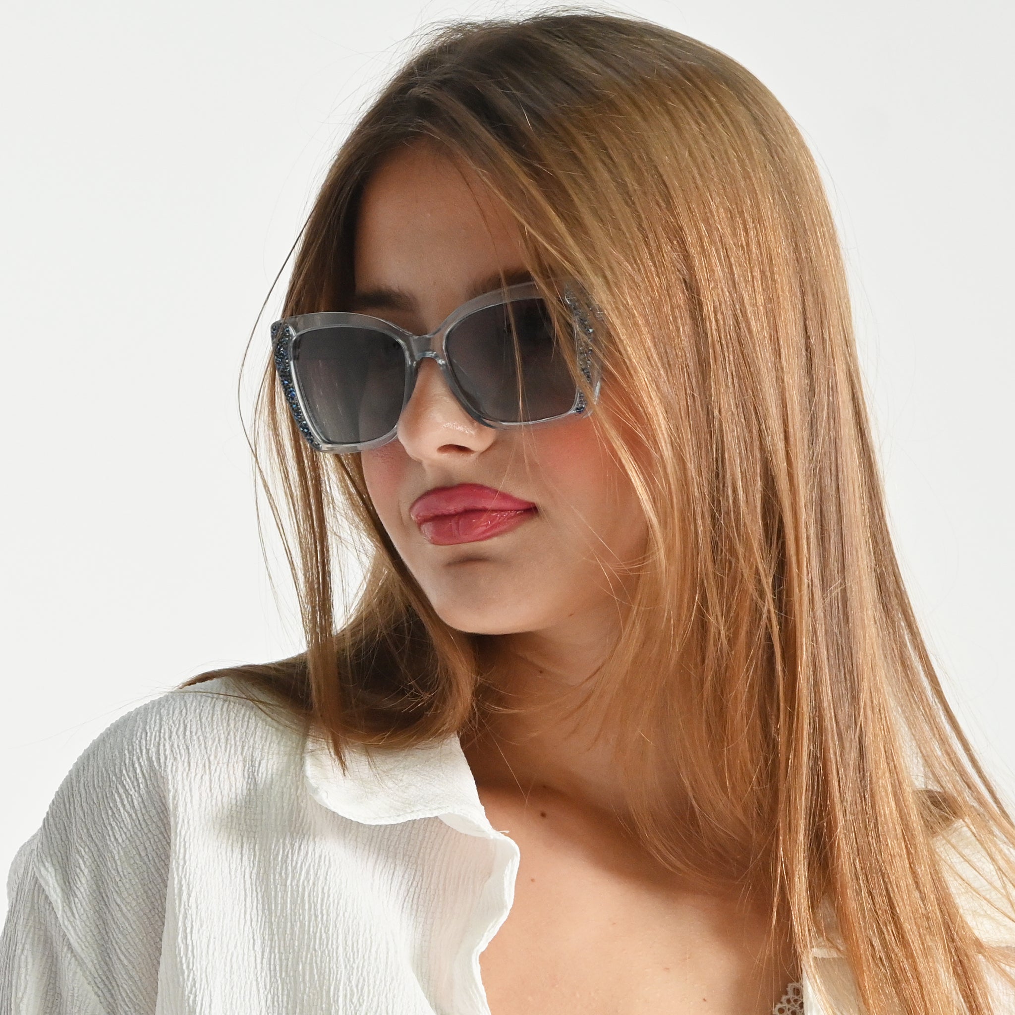 Woman wearing sunglasses with a plain background