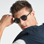 Man wearing black sunglasses with a neutral background