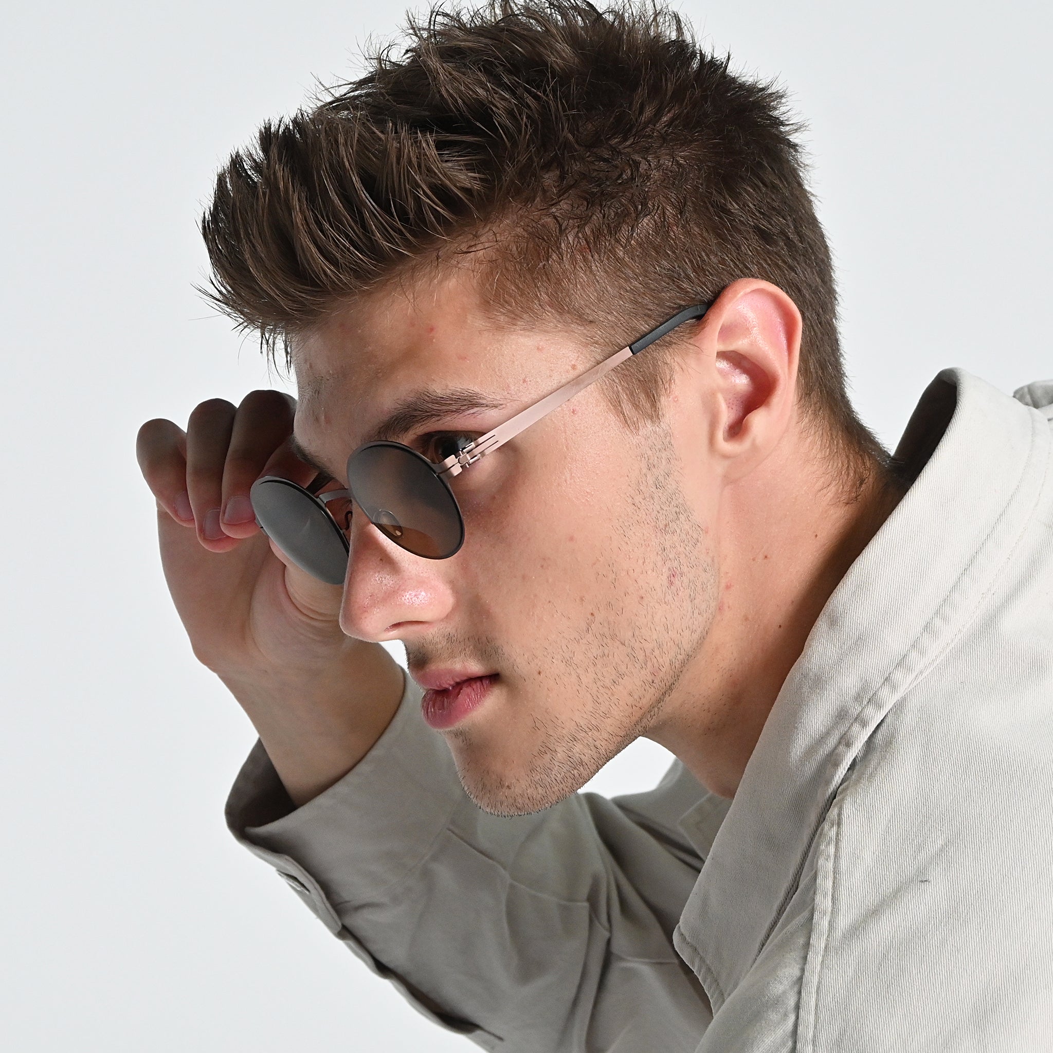 Man wearing sunglasses with a neutral background