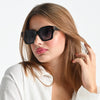 Woman wearing black sunglasses with a plain background