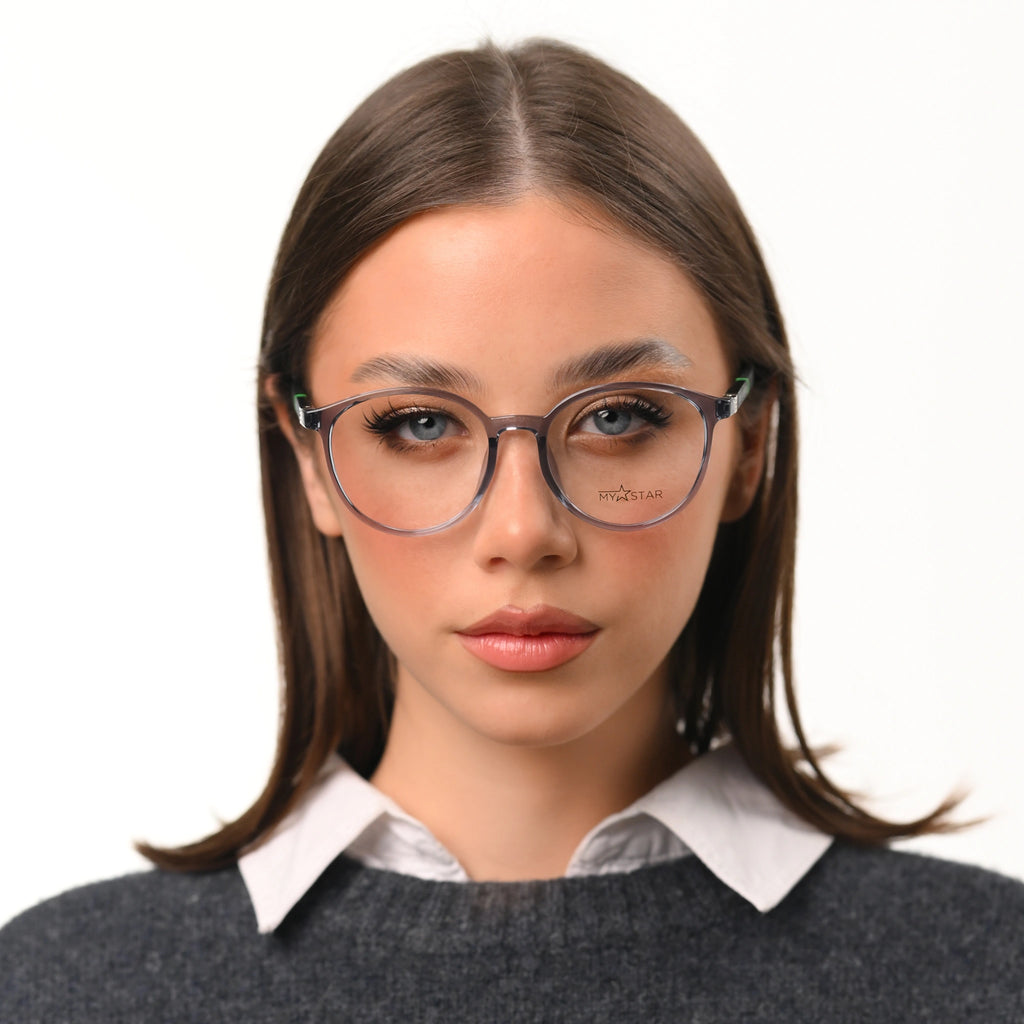Woman wearing glasses with a white shirt and gray sweater on a white background