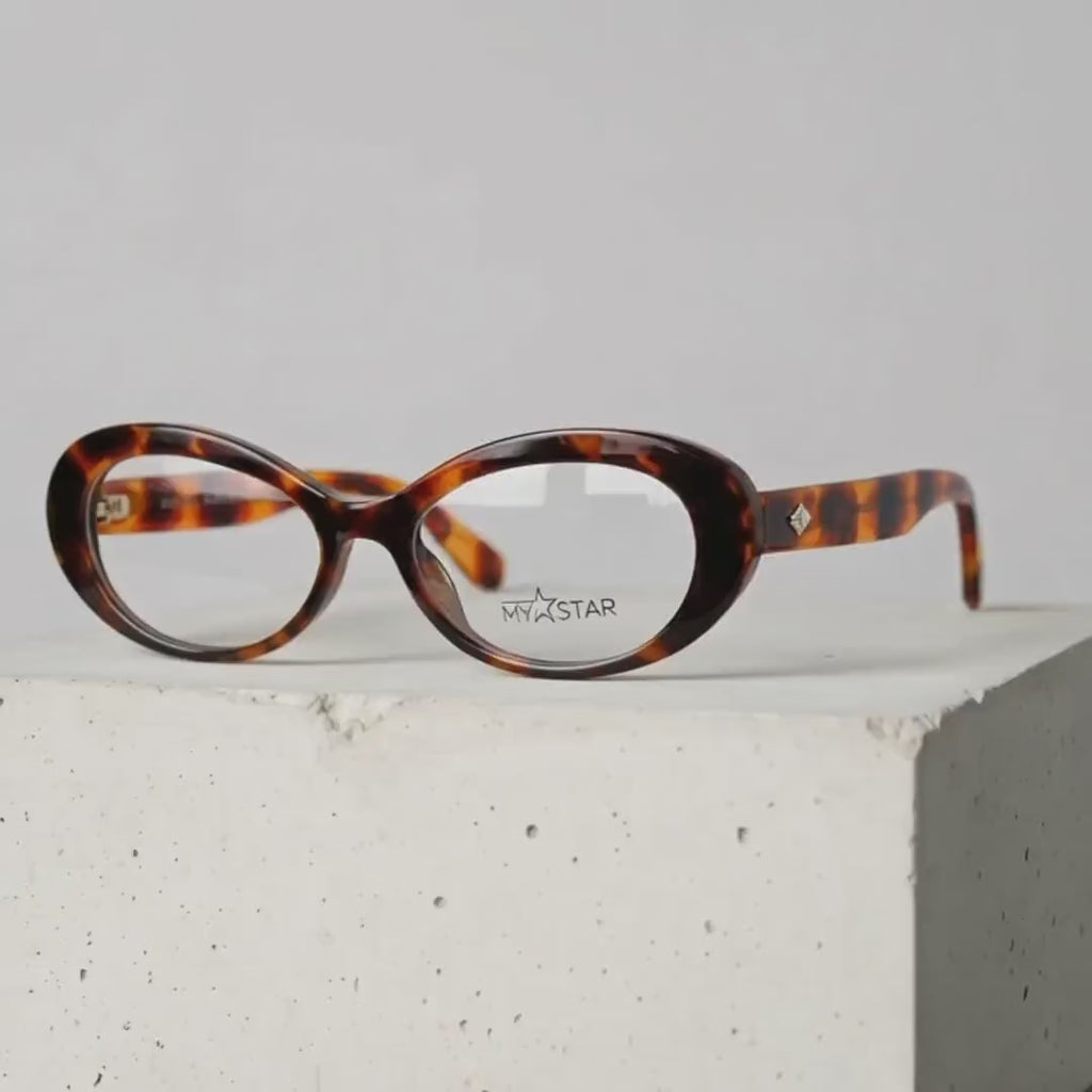 Tortoise oval MyStar eyeglasses frame on a white display block.