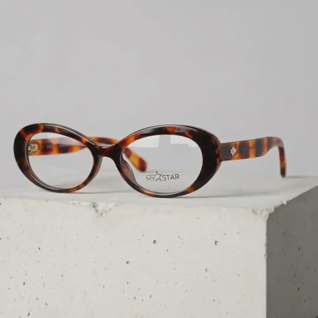Tortoise oval MyStar eyeglasses frame on a white display block.