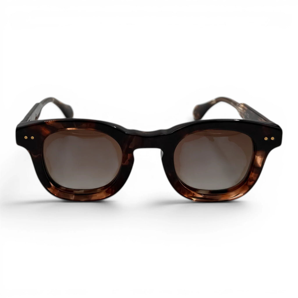 Sunglasses with tortoiseshell frame and dark lenses on a white background