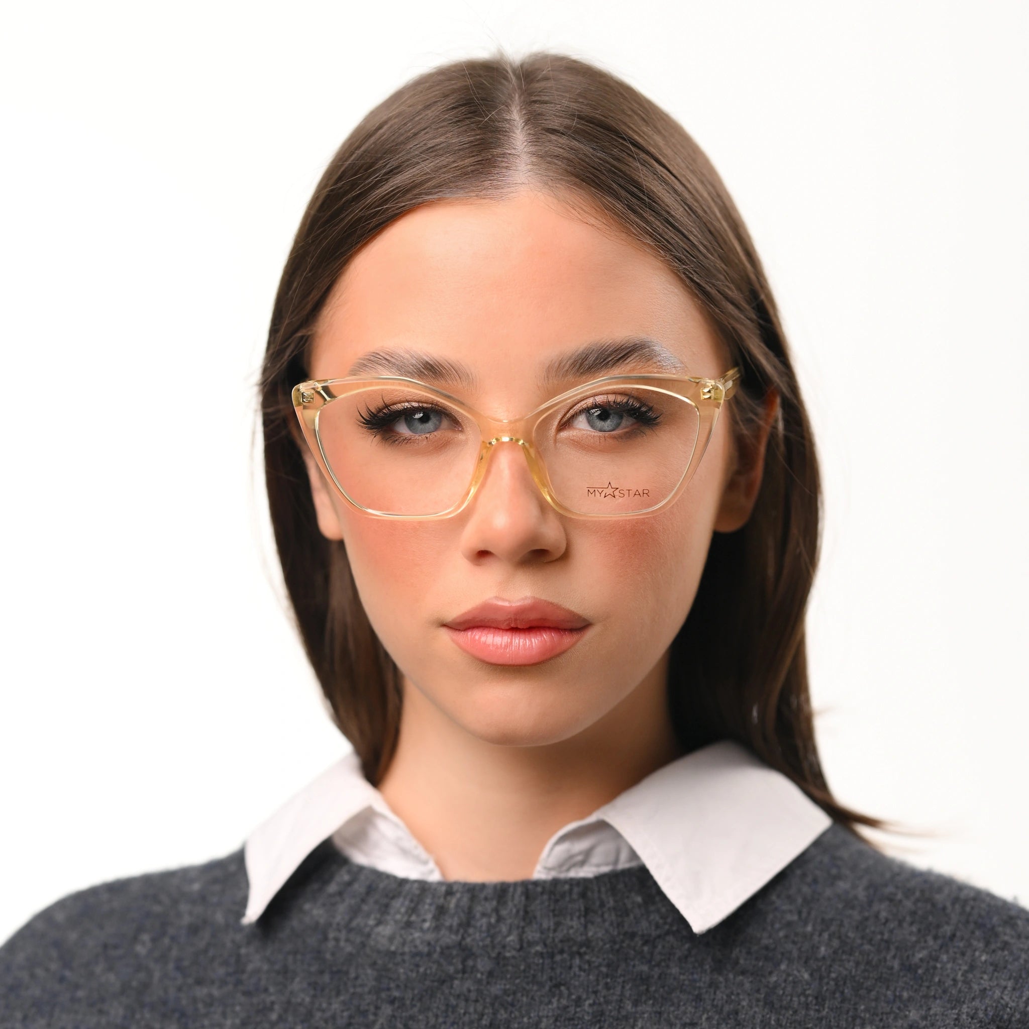 Woman wearing gold-framed glasses with a plain background