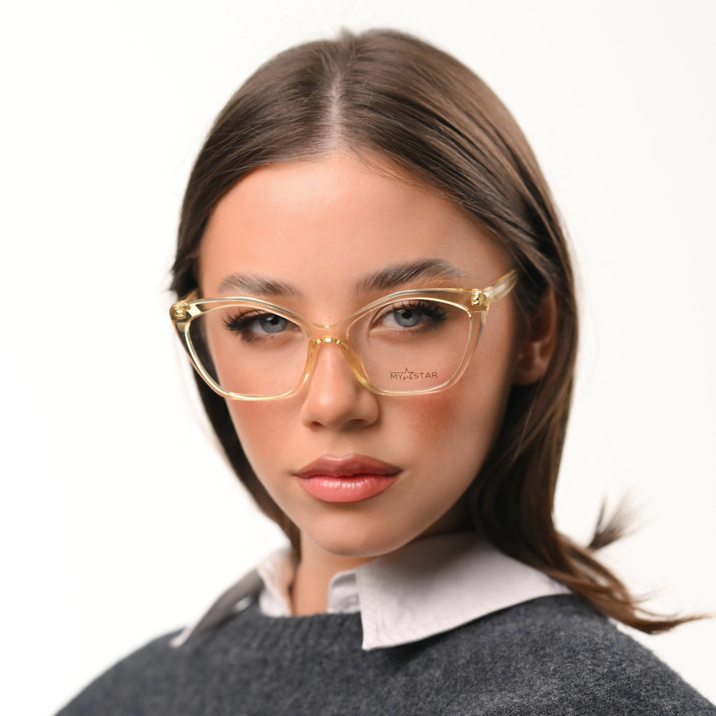 Woman wearing gold-framed glasses with a plain background